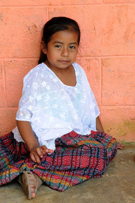 An indigenous Mayan girl sits outside a health center in rural Guatemala.