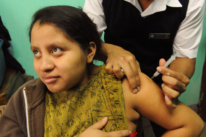 A pregnant woman receives a tetanus vaccination at a rural health center in rural Sacanilla, Guatemala.