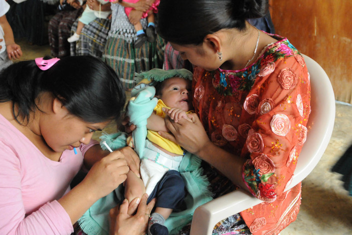 A health worker administers a pentavalent vaccine injection to a 3-month-old infant in rural Guatemala.