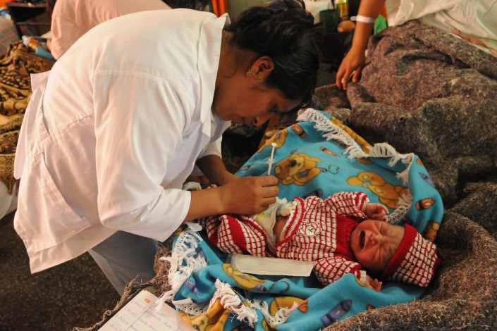A nurse immunizes a 1-day-old infant boy against Hepatitis B, in a maternity ward in Coban, Guatemala.