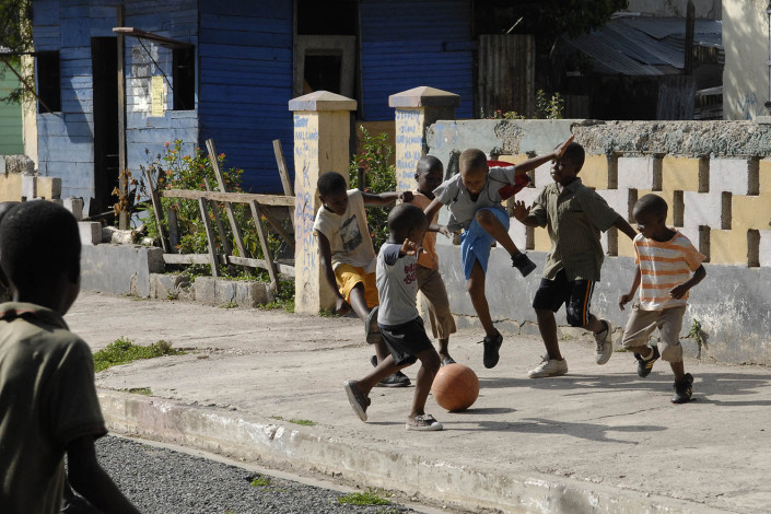 A group of boys play football or soccer on a Trenchtown street in the parish of Kingston and St. Andrew, Jamaica.