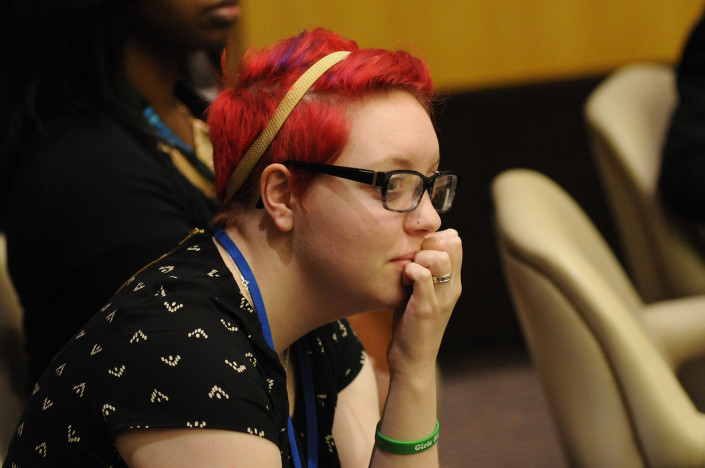 A woman with red hair listens during at meeting at the United Nations.