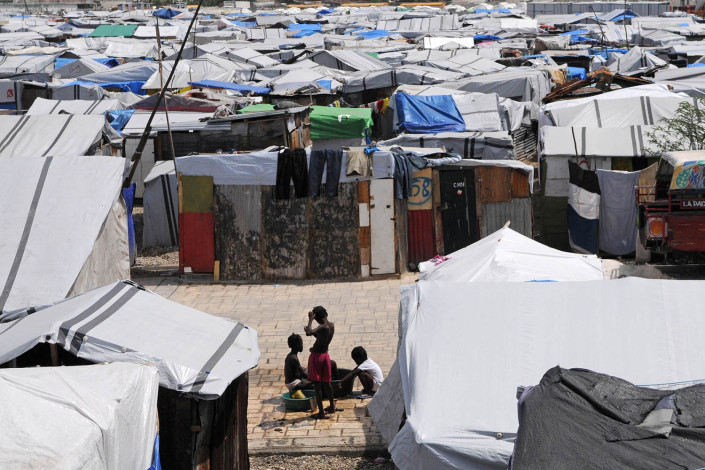 Displaced persons bathe amid tents in Carrefour Aviation, a tent camp for displaced persons in Haiti