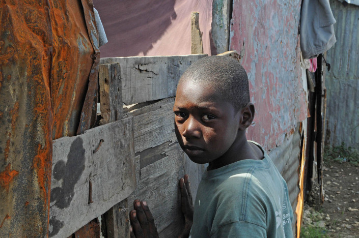 A boy leans against his makeshift home after the earthquake in Port-au-Prince, Haiti.
