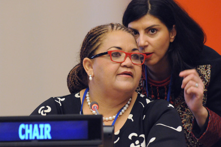 Women confer privately at a meeting at the United Nations.
