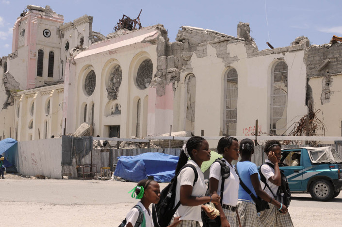 A group of adolescent girls walk to school past homes devastated by the 7.3 magnitude earthquake which took place on 12 January 2010, in Port-au-Prince, Haiti.