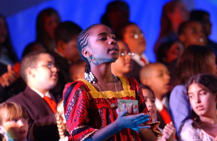 A girls sings during a choral performance.