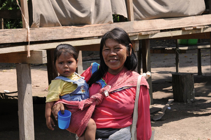 A woman holds her young daughter outside their home in the indigenous community of Nuevo Saposoa in the Peruvian Amazon.