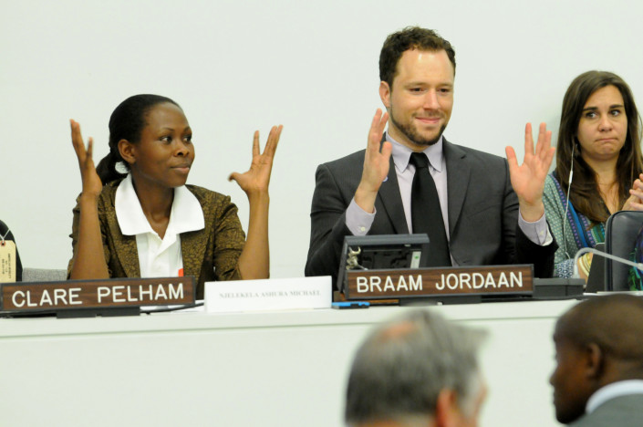 Disability activists at the UN sign their applause in sign language at a conference.
