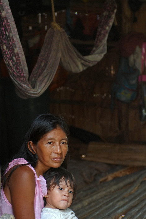 An indigenous Añu woman sits inside her home with her 1-year-old daughter, in Laguna de Sinamaica, Venezuela.