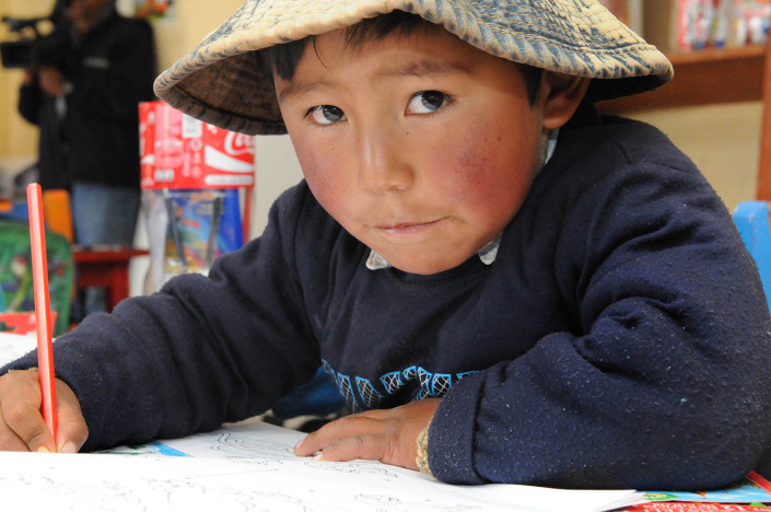 A boy sits at his desk in a classroom at Robertito School at the Cerro Rico Mines in the city of Potosí, Bolivia.