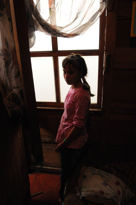 A girl stands in front of a window in her foster home in Guatemala.
