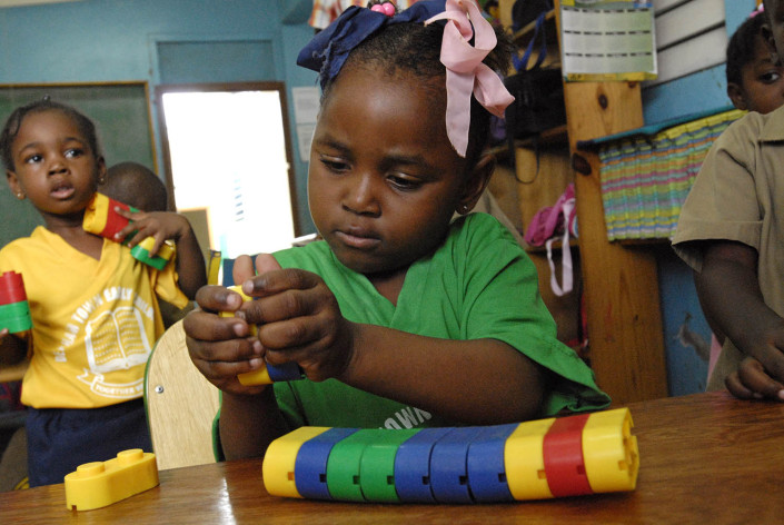 A girl plays with colourful plastic blocks at the UNICEF-supported Denham Town Basic School in the Denham Town community in the parish of Kingston and St. Andrew, Jamaica.