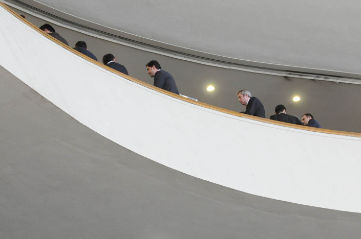 Delegates lean against a high ledge at the United Nations during a break.