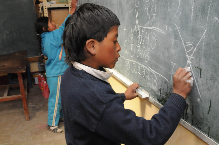Children write on the blackboard at a school at the Cerro Rico Mines in Potosí, Bolivia.