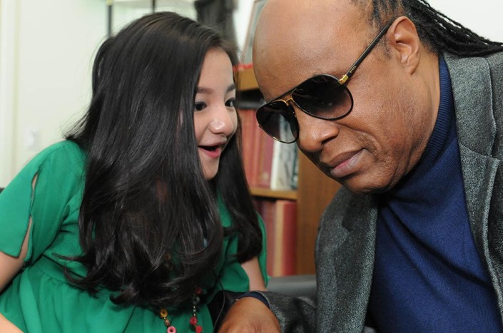 Singer/songwriter Stevie Wonder listens intently to a 16-year-old girl at the United Nations.