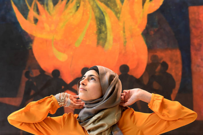 Minimill Sarfraz, 15, stands in front of a painted mural echoing the colors of her blouse, at UN Headquarters.