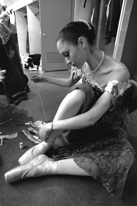 A ballerina from the Royal Flanders Ballet adjusts her pointe shoes.