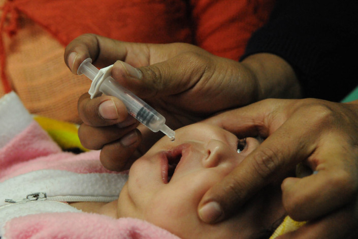 A 2-month-old infant receives a rotavirus vaccination at a rural health center in Guatemala.