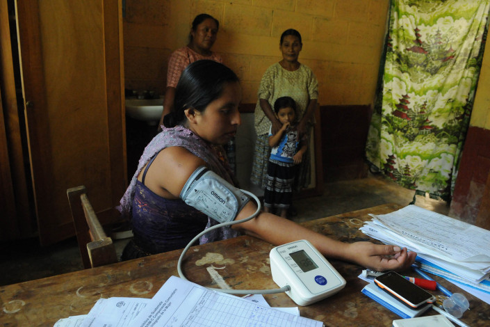 An indigenous Mayan woman, 7 months pregnant, has her blood pressure monitored at a rural health center in Guatemala.
