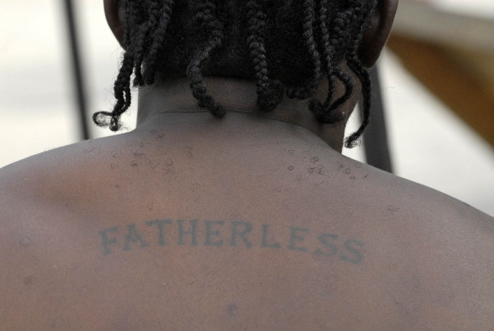 A member of the Fatherless gang shows his tattoo, bearing the name of his gang, in Rema, parish of Kingston and St. Andrew, Jamaica.