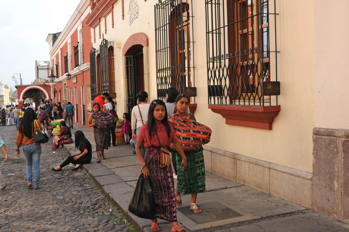 Two young girls walk down a street in Antigua, Guatemala.