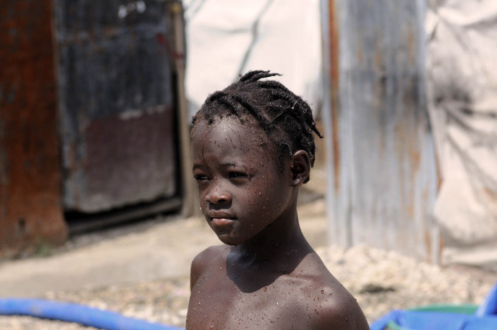 A young girl in Carrefour Aviation, a camp for people displaced by the Haiti earthquake, showers outdoors in Port-au-Prince, Haiti.