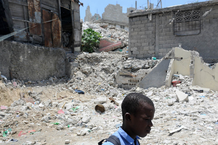 A boy walks to school past homes devastated by the 7.3 magnitude earthquake which took place on 12 January 2010, in Port-au-Prince, Haiti.