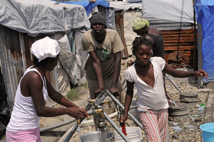 A girl collects water at Carrefour Aviation, a tent camp housing 50,000 people who were displaced by the 7.3 magnitude earthquake on 12 January in Haiti.