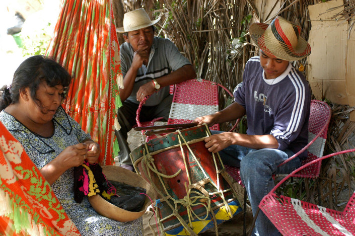 Indigenous Wayuu adolescent prepares musical instruments for a traditional dance.