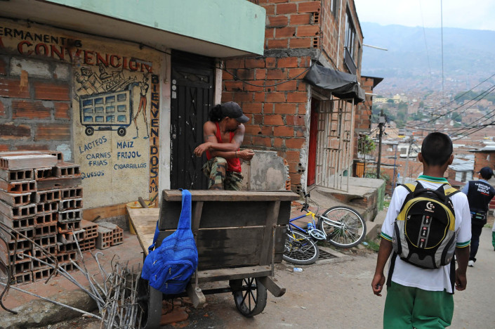 An adolescent boy walks home from school in a city in Colombia.