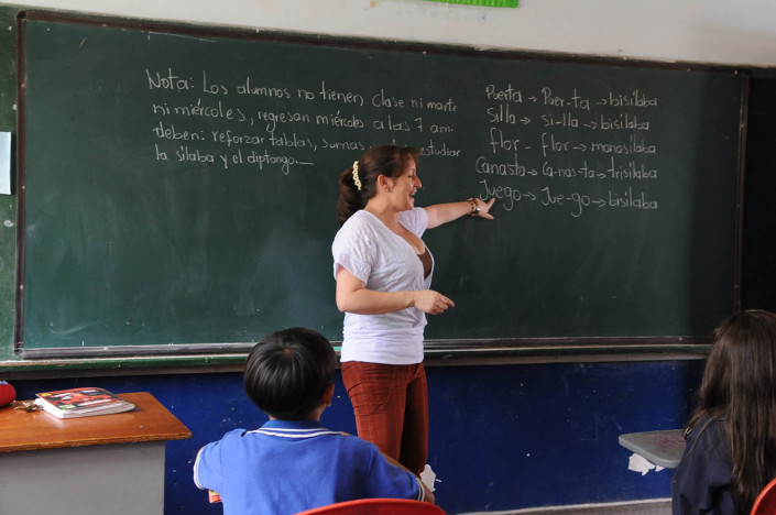 A teacher points to the blackboard during a Spanish class for third-graders in Medellín, Colombia.