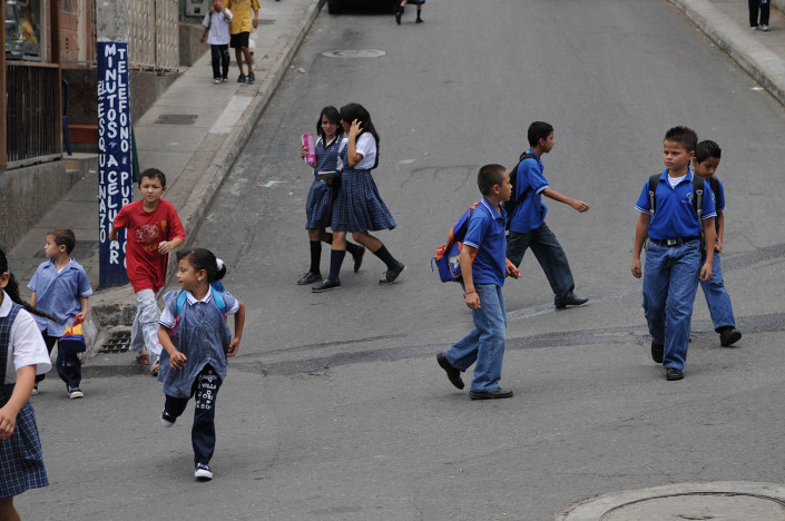 Children cross the street on their way home from school in Medellín, Colombia.