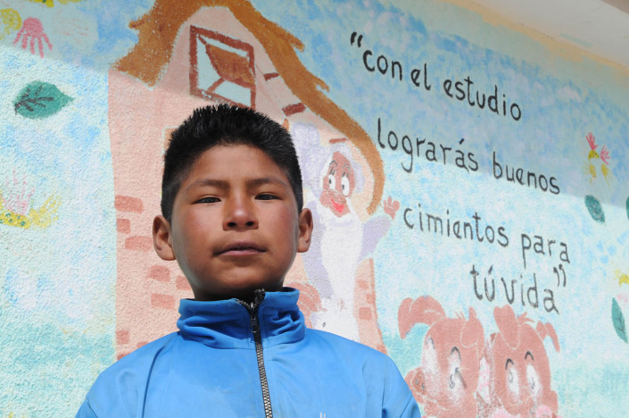 Roberto, 11, sands in front of a mural at the Roberto School in the city of Potosí, Bolivia.