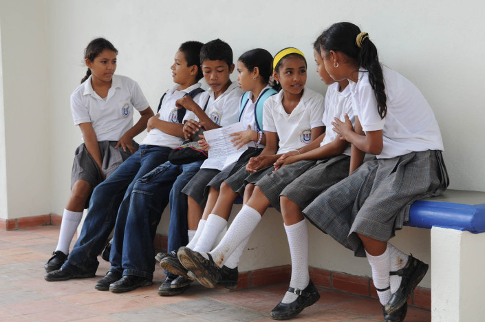 Girls and boys chat with each other outside their classroom in Lorica, Colombia.