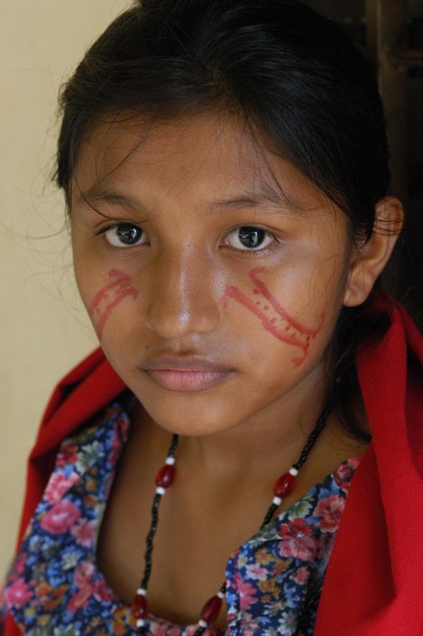 An indigenous 15-year-old-girl in traditional dress and paint, prepares for a traditional dance.