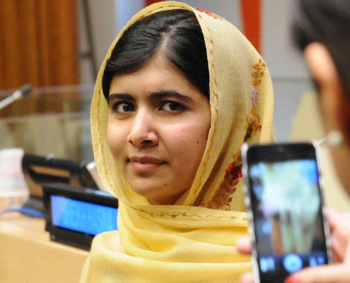 Education activist Malala Yousafzai, wearing a yellow dress and head covering, at the UN.