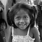 A smiling indigenous Shipibo Conibo girl stands outside a community center near her home in the Peruvian Amazon.