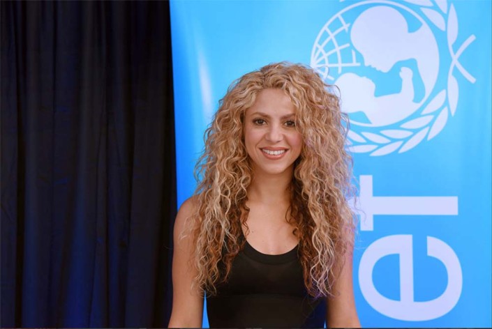 UNICEF Goodwill Ambassador and internationally renowned singer songwriter Shakira stands in front of a banner with a UNICEF logo in an official portrait.